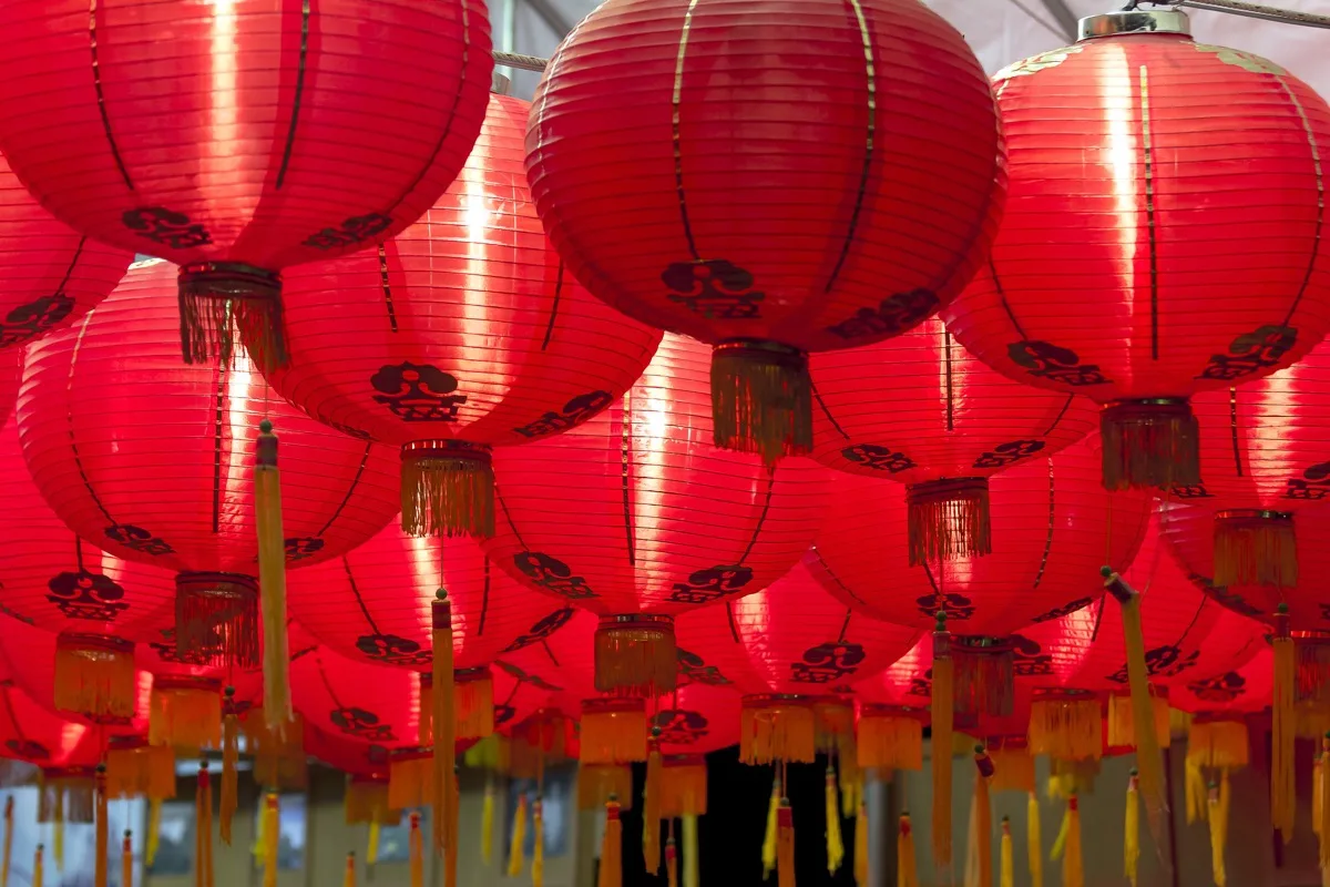 Rows of illuminated red lanterns hanging overhead for a Chinese celebration