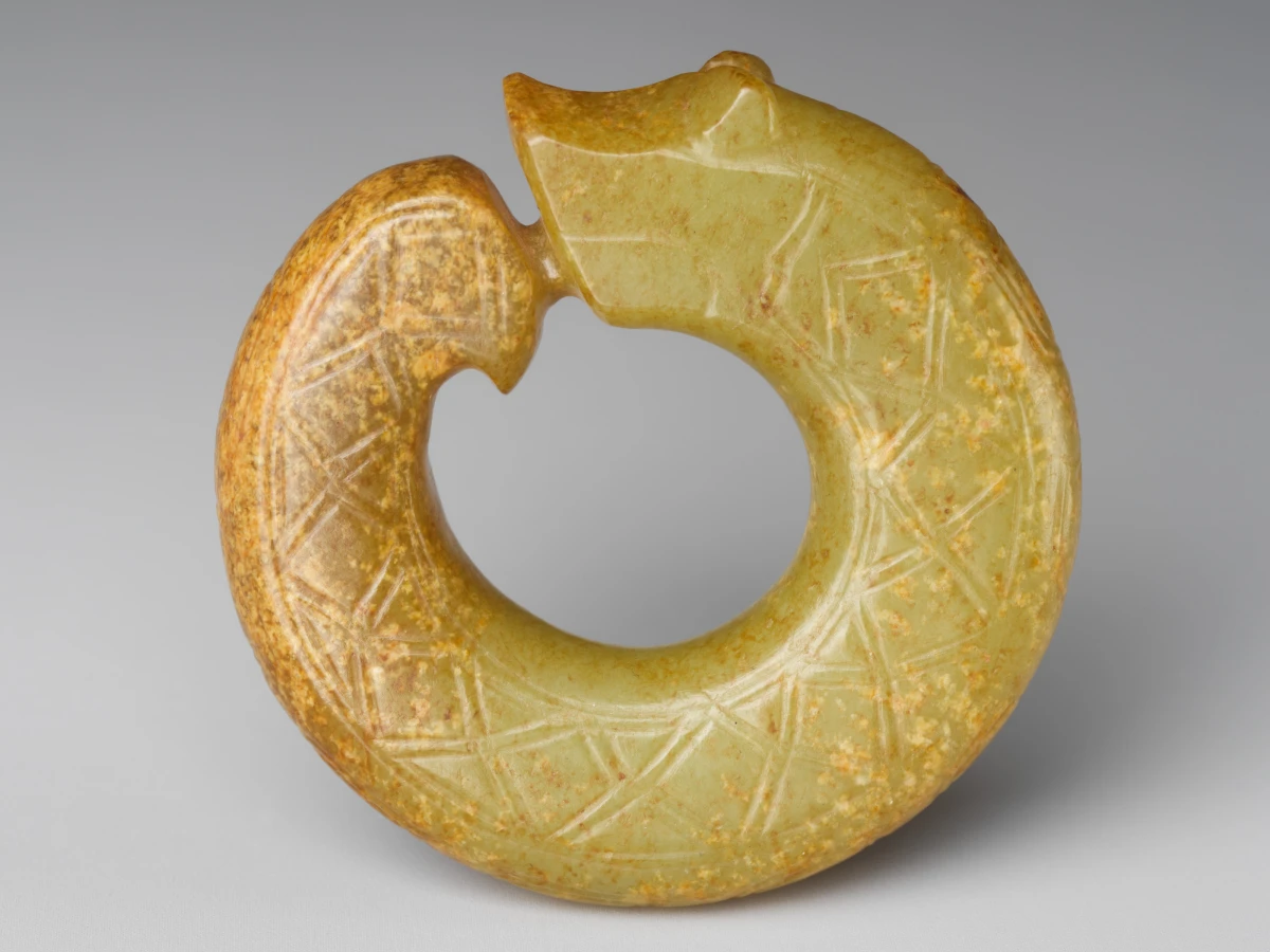 Detail of a yellow-green nephrite pendant carved as a coiling dragon
